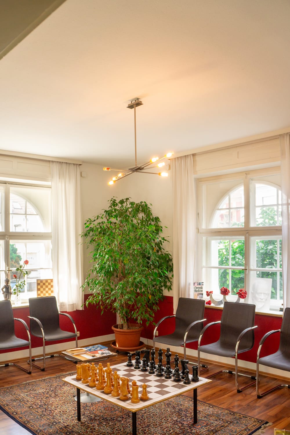 Helles Wartezimmer der Praxis mit Schachtisch